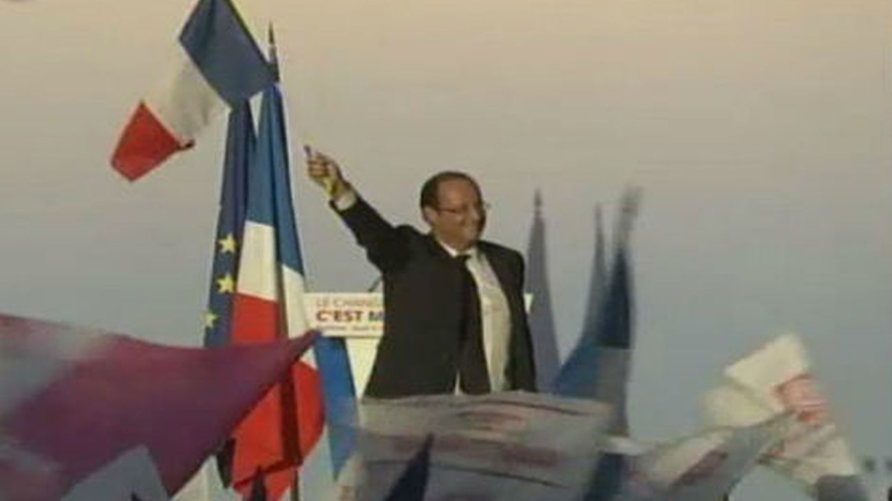 Hollande con la bandera de Francia en un mítin