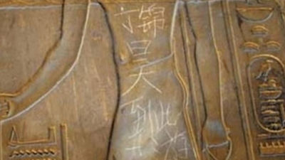 Un joven chino pinta en una de las paredes del antiguo templo de Luxor (Egipto)