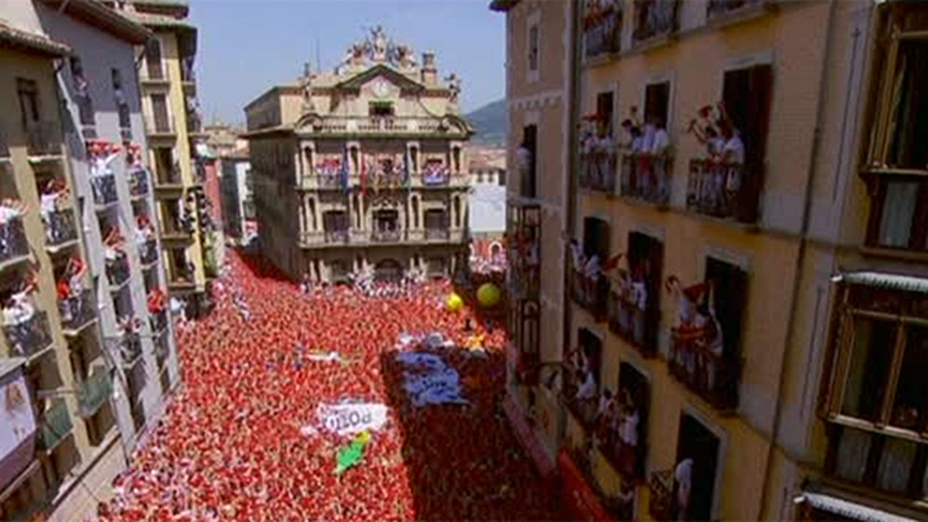 Un masivo y caluroso chupinazo abre los Sanfermines con la ikurriña en el balcón