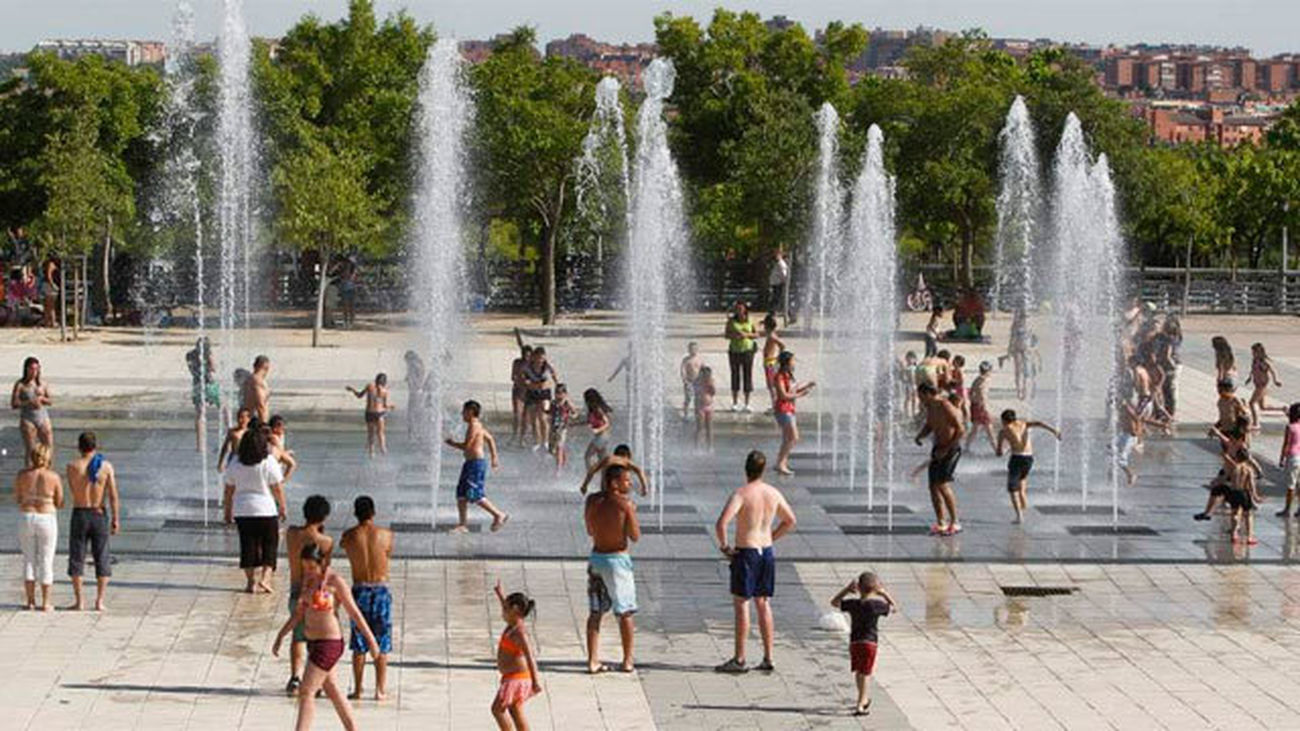 Los madrileños combaten la ola de calor refrescándose en Madrid Río