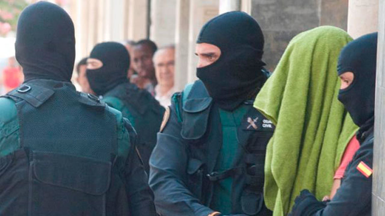 Agentes de la Guarcia Civil escoltan a uno de los detenidos en Girona