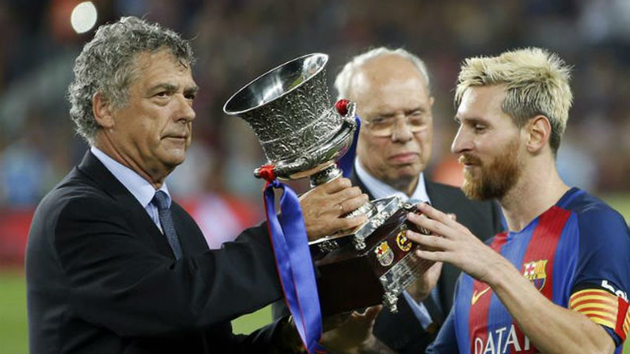 El capitán del FC Barcelona, Leo Messi recibe el trofeo de campeón de la Supercopa de España de manos del presidente de la FEF