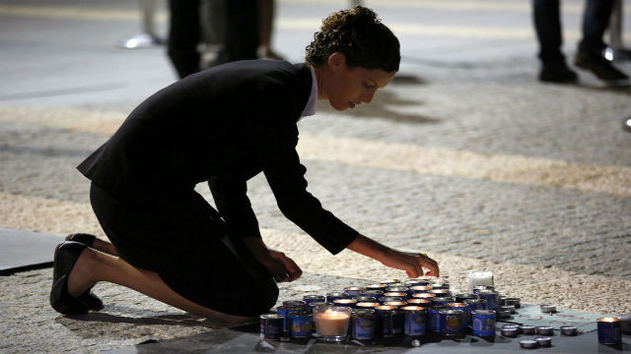 Una mujer deja una vela ante el féretro del expresidente israelí Simón Peres