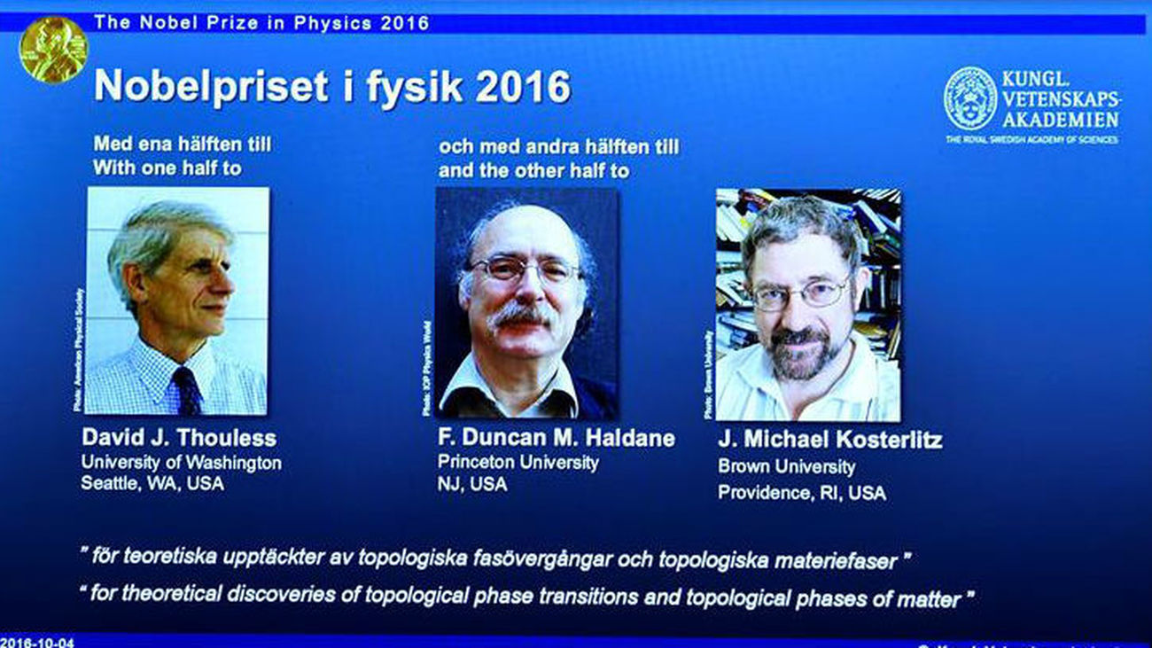 Imagen de una pantalla en la Academia de Ciencias de Estocolmo, Suecia, que muestra a los científicos británicos David Thouless