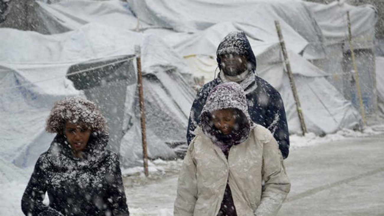 Varios refugiados caminan bajo la nieve en el campamento de refugiados de Moria, en la isla de Lesbos, Grecia