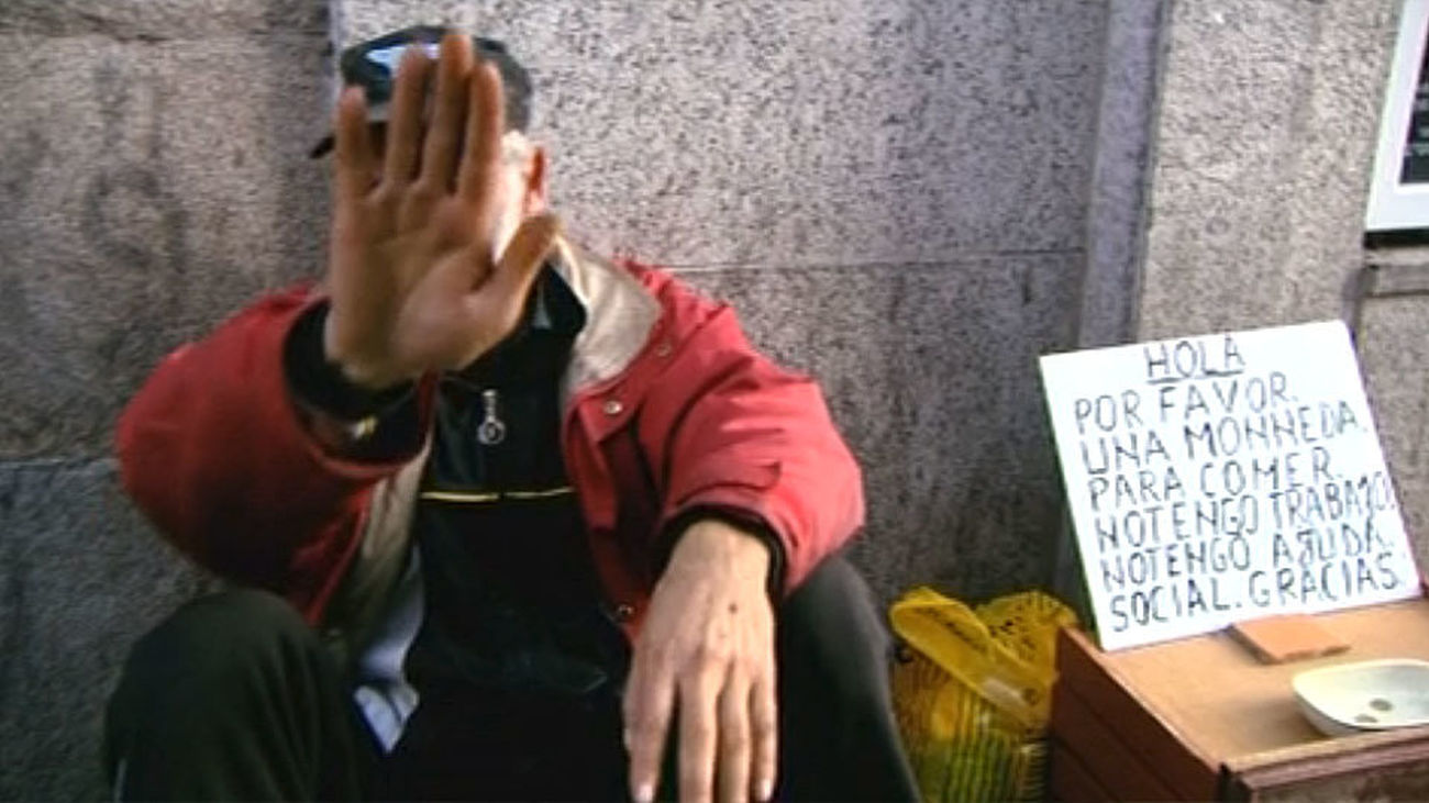 Un mendigo pide limosna en la calle, Madrid