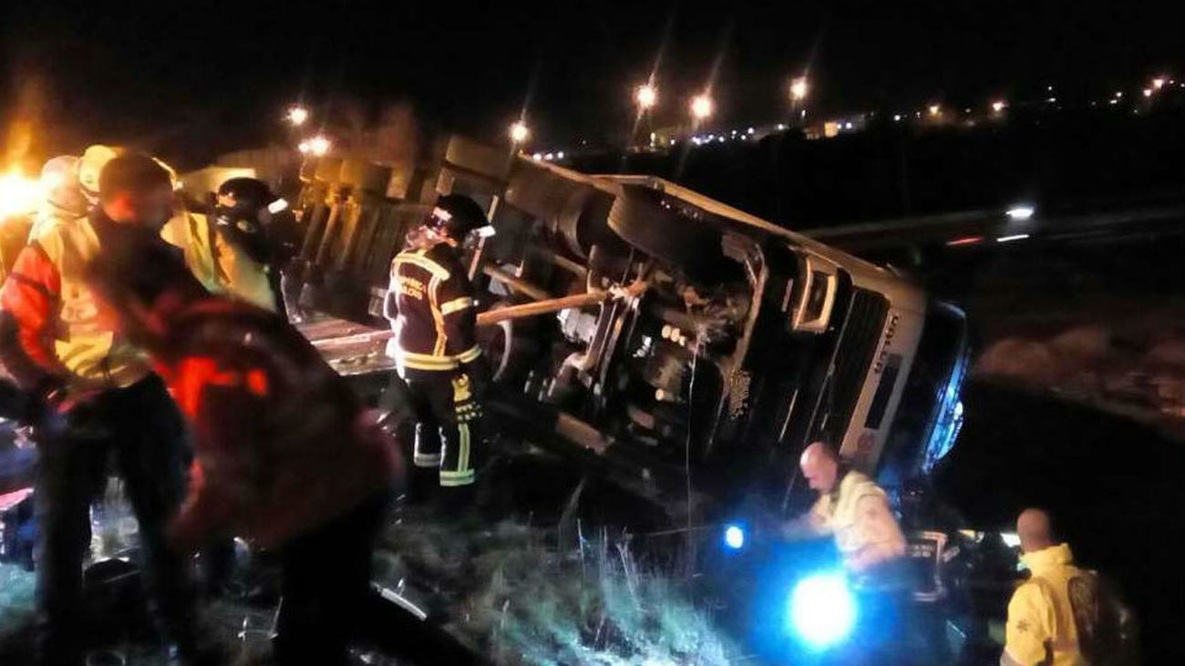 Los bomberos rescatan a un camionero atrapado tras volcar su trailer en la M-45
