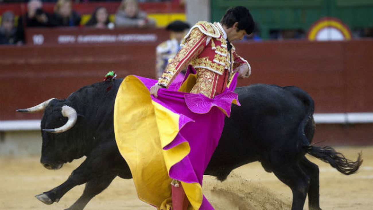 El diestro Sebastián Castella, que cortó dos orejas, da un pase con el capote a uno de los de su lote