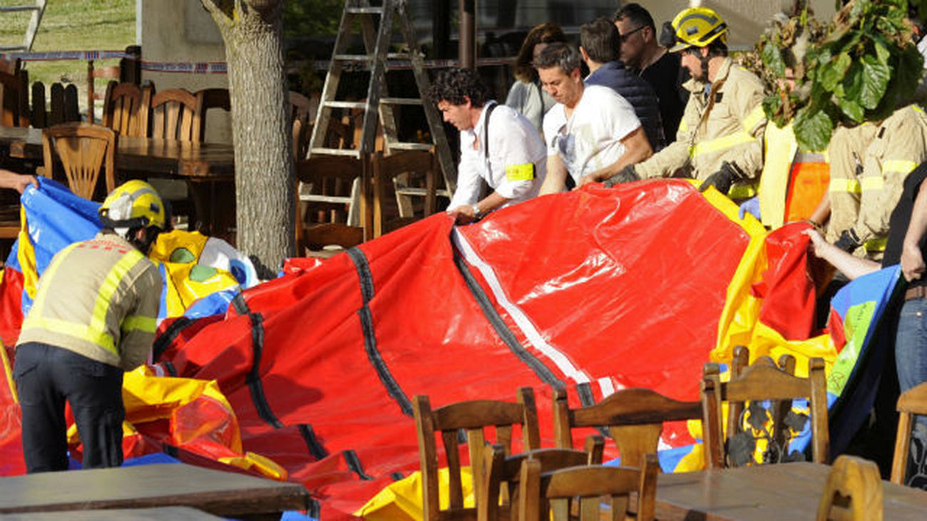 Varios operarios y bomberos retiran el castillo hinchable del restaurante Mas Oller, de Caldes de Malavella (Gerona)