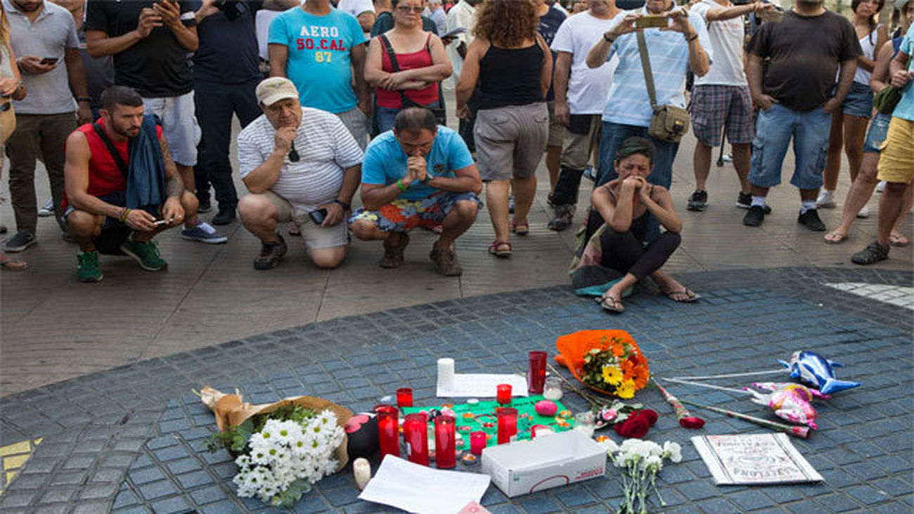 Varias personas se paran frente al mosaico de Miró en las Ramblas de Barcelona después del atentado