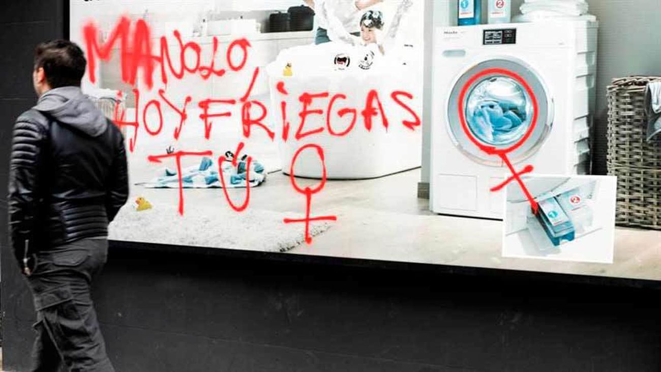 Un joven pasa ante una pintada en una calle de Valencia