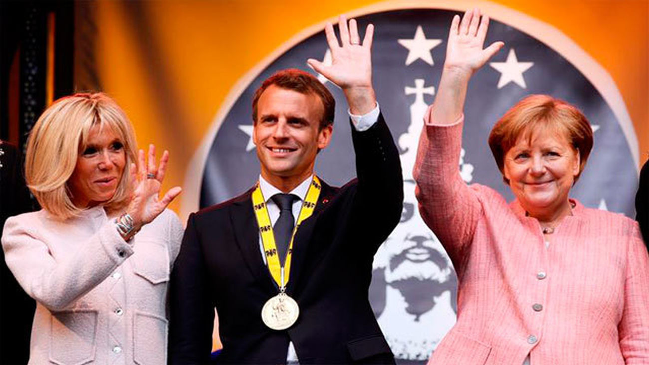 El presidente francés, Emmanuel Macron con su esposa y la canciller alemana, Angela Merkel tras  recibiór el Premio Carlomagno