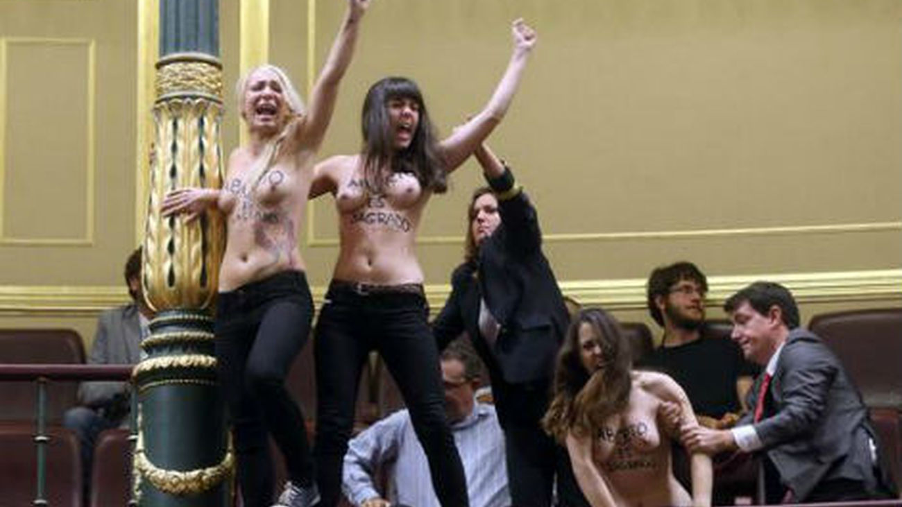 Mujeres semidesnudas interrumpen el pleno al grito de "aborto es sagrado"