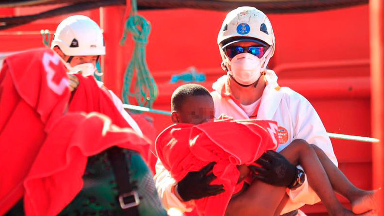 Un efectivo de Salvamento Marítimo lleva en sus brazos a un niño a su llegada al puerto de Algeciras