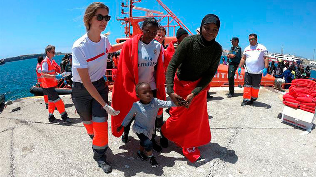 Un bebé y su madre reciben ayuda de los voluntarios de Cruz Roja, en el puerto de Tarifa