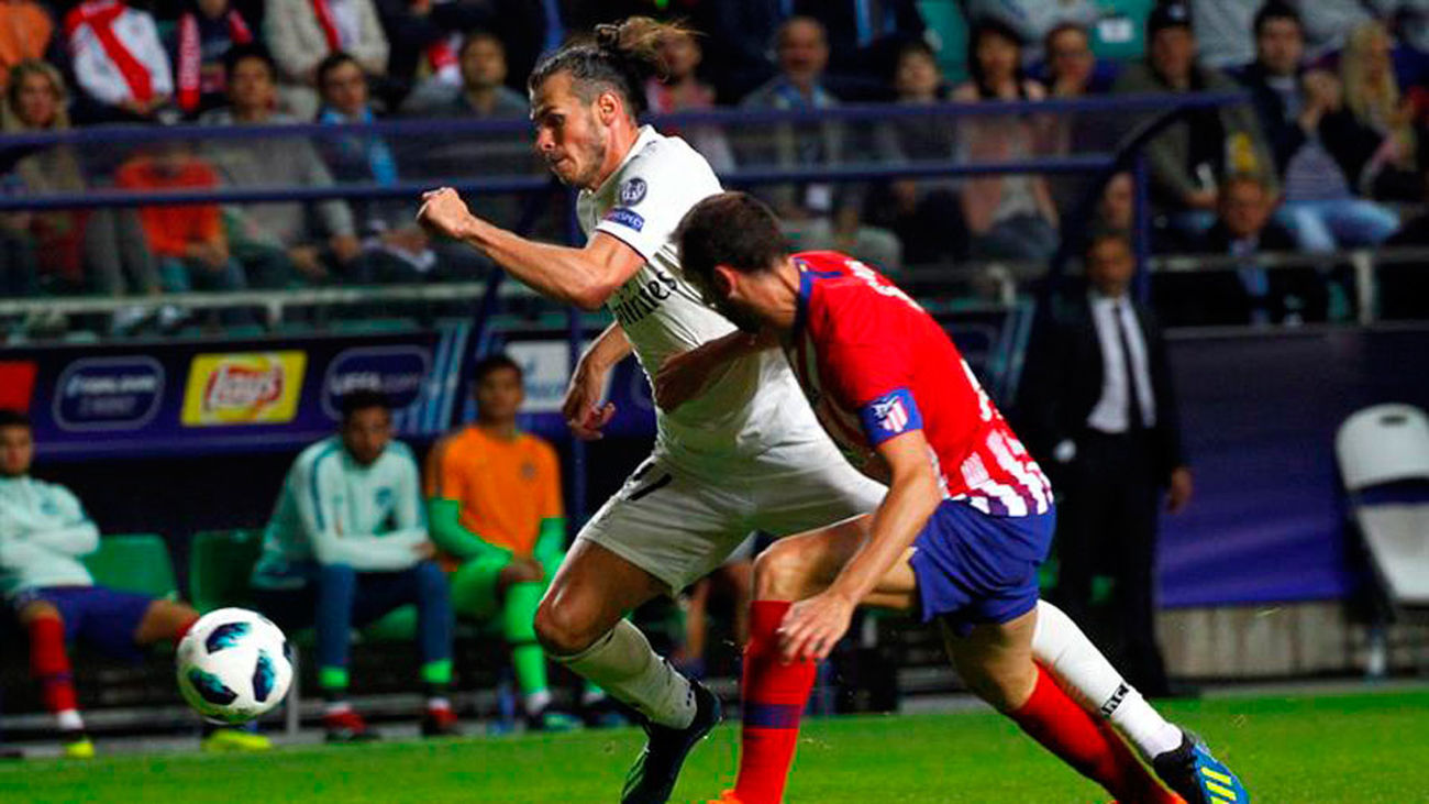 Gareth Bale disputa el balón con Diego Godín