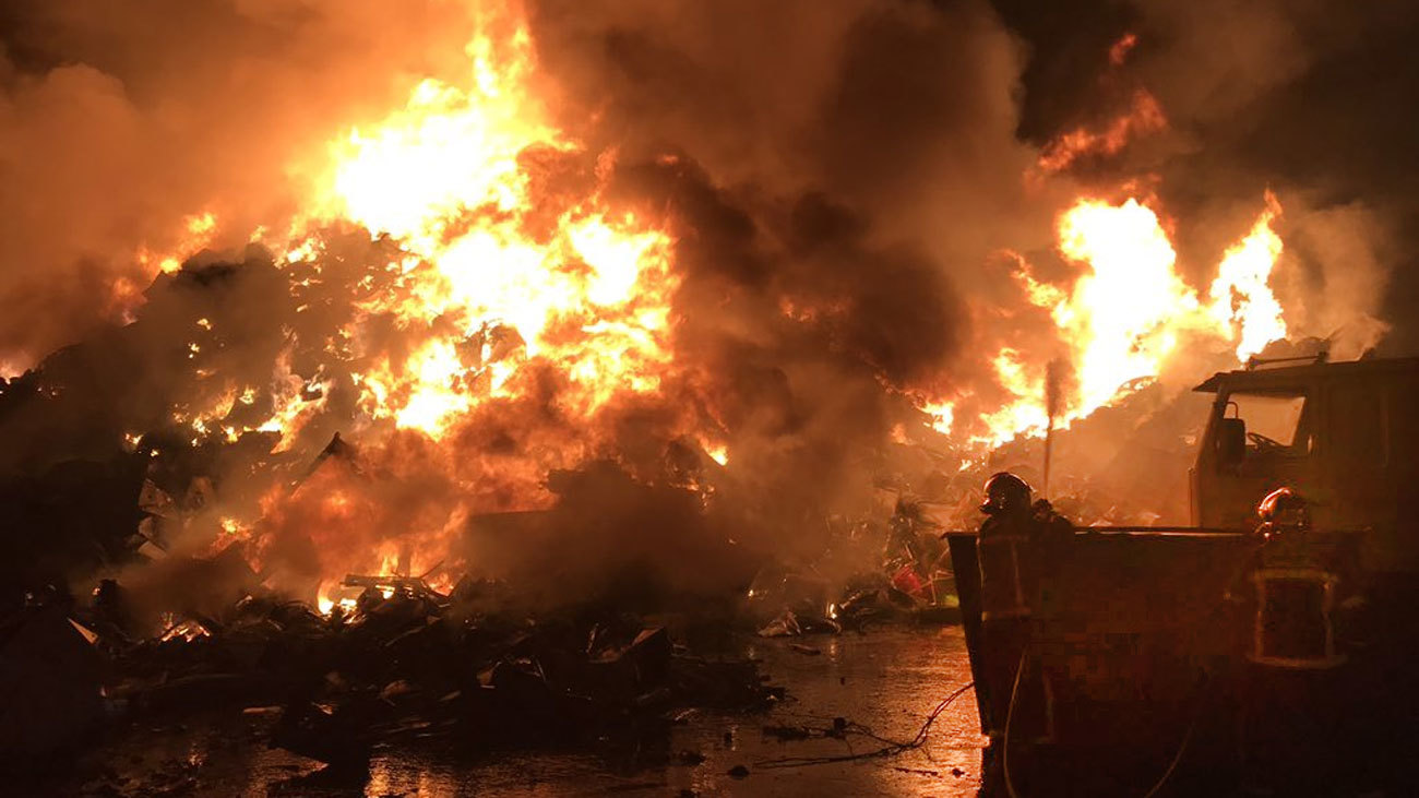 Bomberos de la Comunidad de Madrid participan en las labores de extinción de un incendio declarado en una chatarrería, en San Fernando de Henares