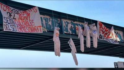 Muñecos con siglas de Cs, PP, PSC, Podemos y Vox colgados de un puente en Lleida