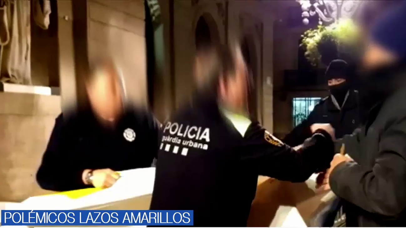 Unos encapuchados retiran el lazo amarillo colgado en el Ayuntamiento de Barcelona