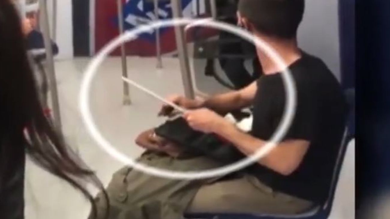 Un hombre afila un cuchillo mientras viaja por la línea 10 de Metro de Madrid