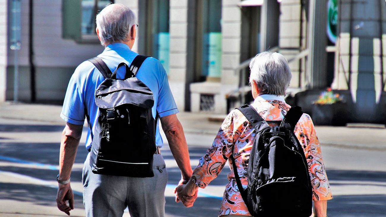 Una pareja de ancianos pasean por el centro de Madrid