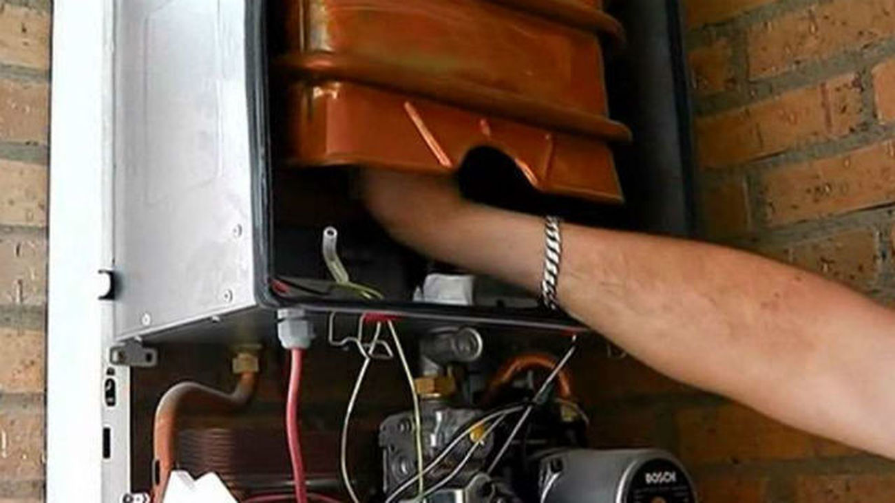Un instalador reparando una caldera de gas.