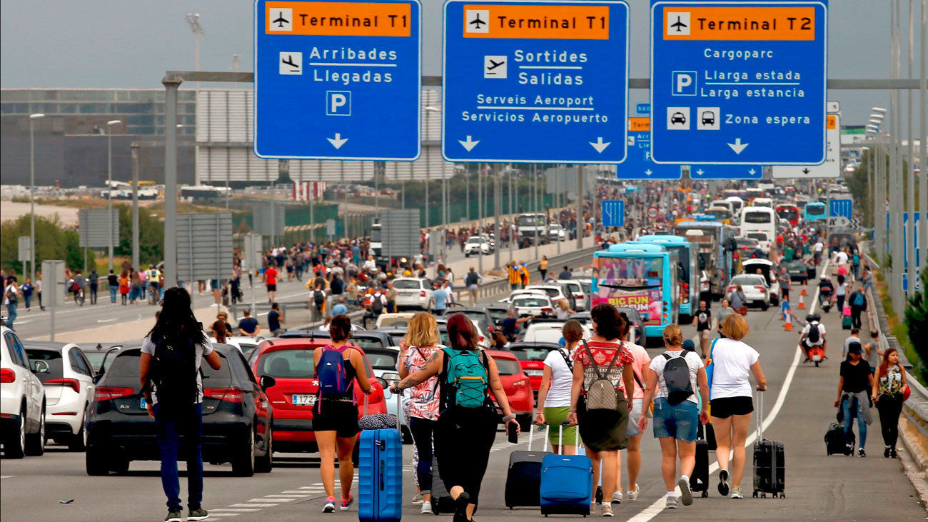 Varios viajeros llegan caminando al Aeropuerto del Prat después de que la plataforma Tsunami Democràtic paralizara la actividad del aeropuerto