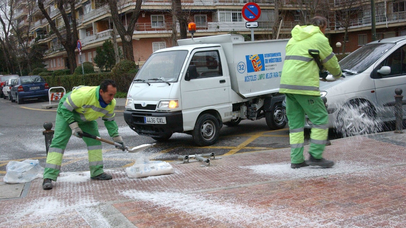 Trabajadores de la limpieza esparcen sal