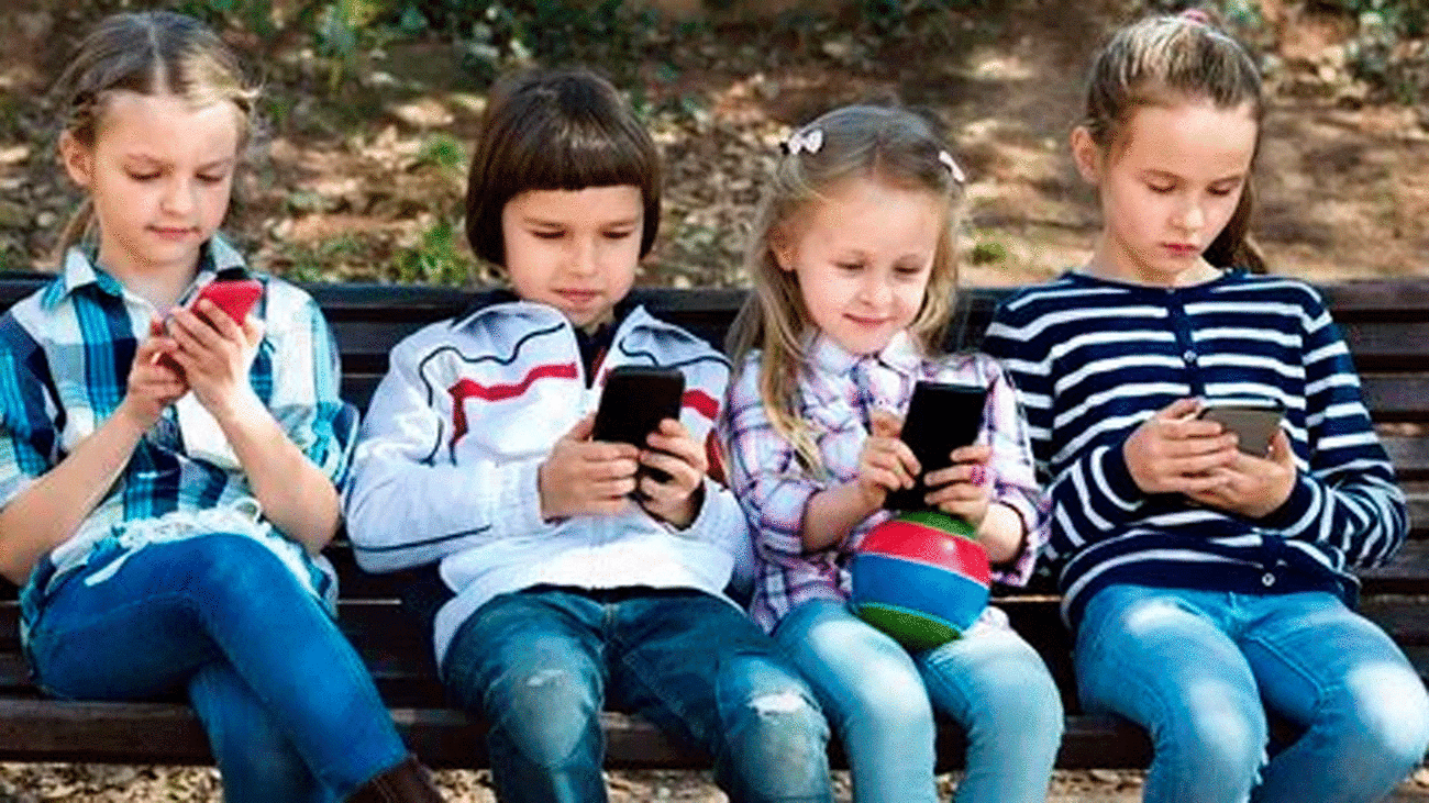 Varios niños juegan con sus teléfonos móviles