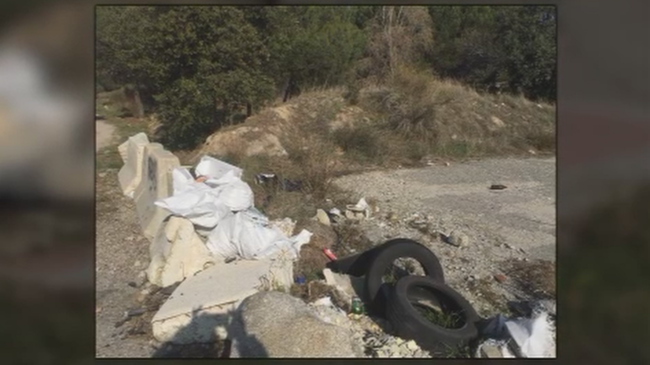 Baches y acumulación de basura en la carretera de acceso a Collado Villalba