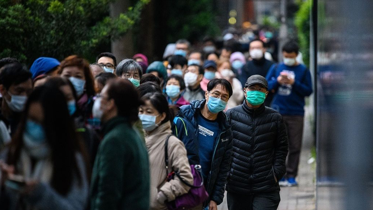 Numerosas personas esperan una cola con mascarillas para evitar el coronavirus chino