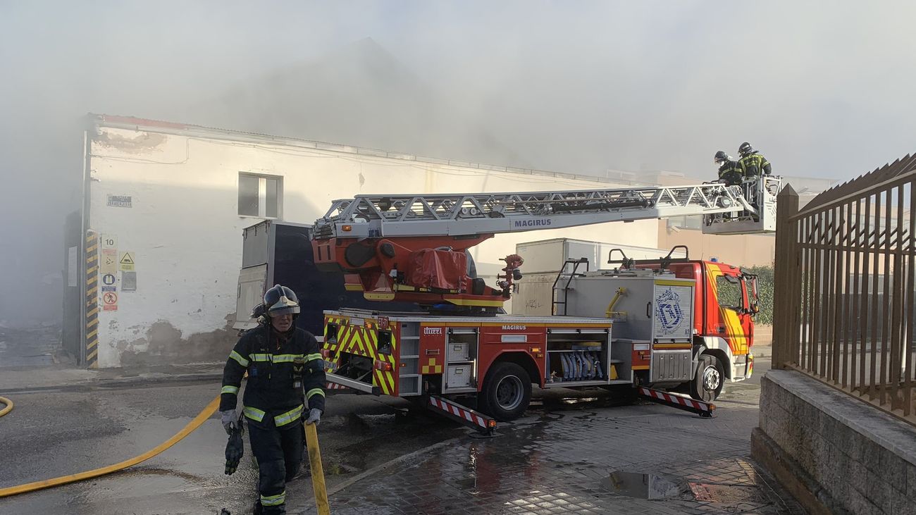 Los bomberos extinguen un incendio en una nave de reciclaje de papel en San Blas