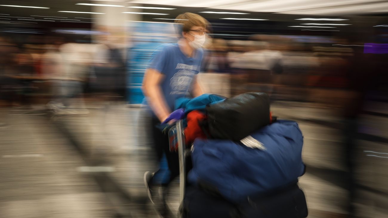Un viajero transporta maletas en un aeropuerto