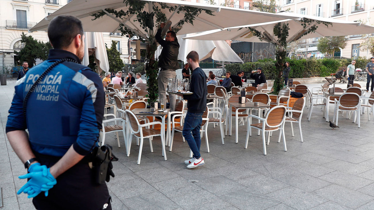 Un policía municipal de Madrid supervisa el cierre de una terraza en la crisis de coronavirus