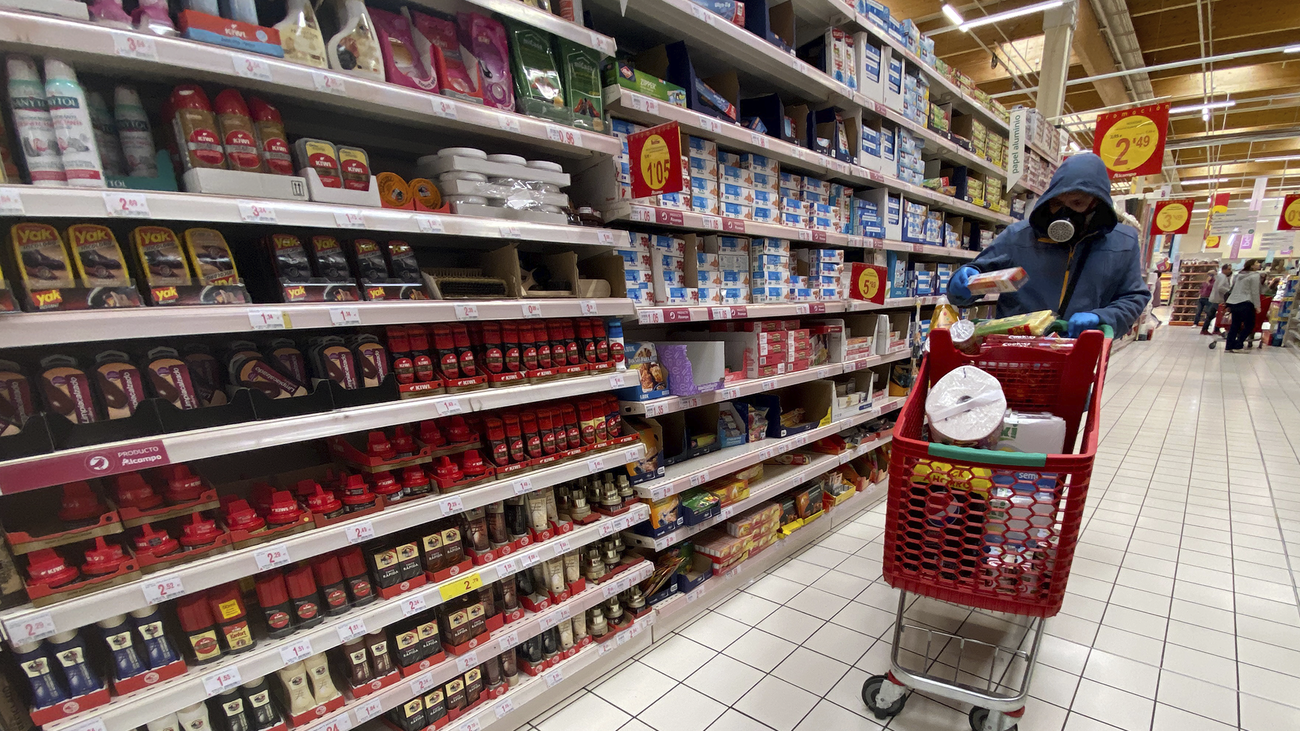 Una persona con mascarilla realiza la compra en el supermercado