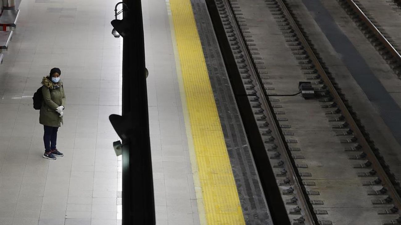 Una persona con mascarilla espera en un andén de Cercanías