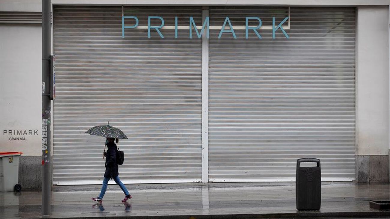 Una joven camina ante la tienda de Primark cerrada en Gran Vía por el coronavirus