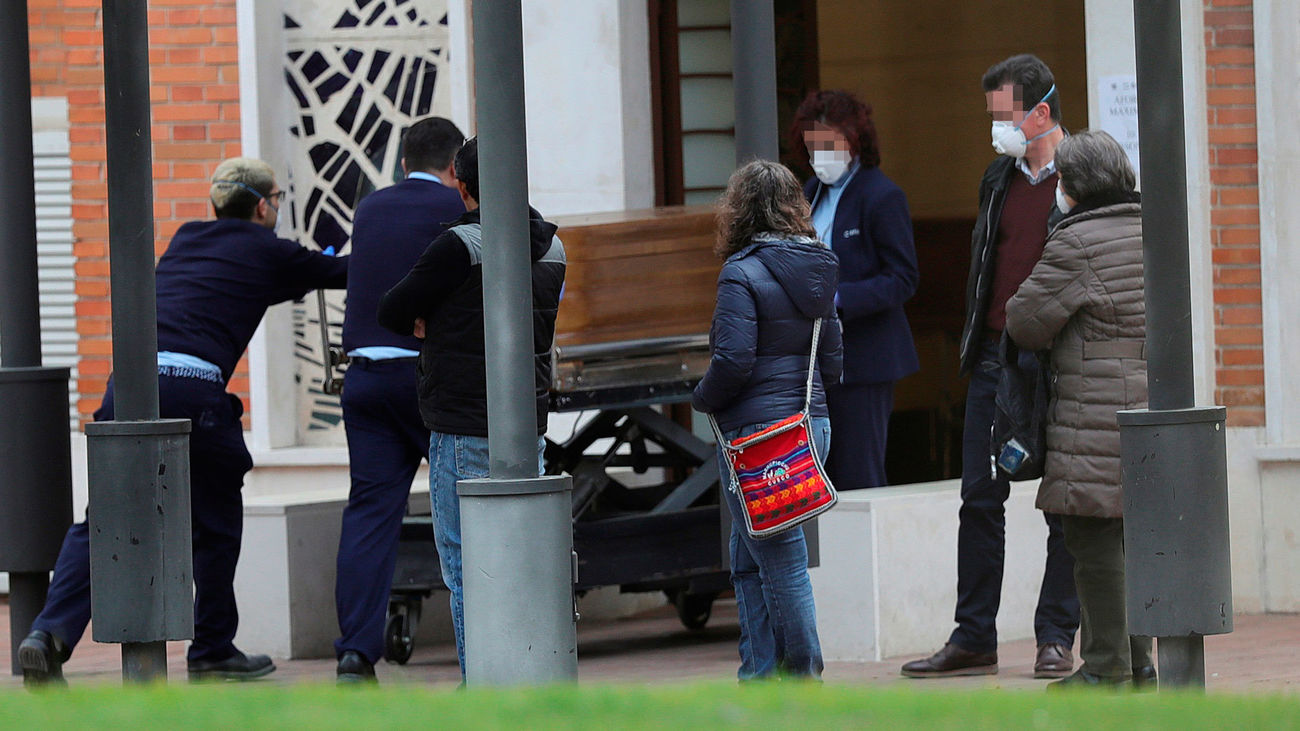 Un grupo de personas esperan la llegada de un féretro en el cementerio de La Almudena