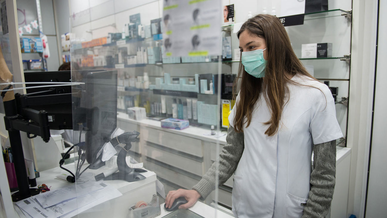 Una farmacéutica protegida con mascarilla