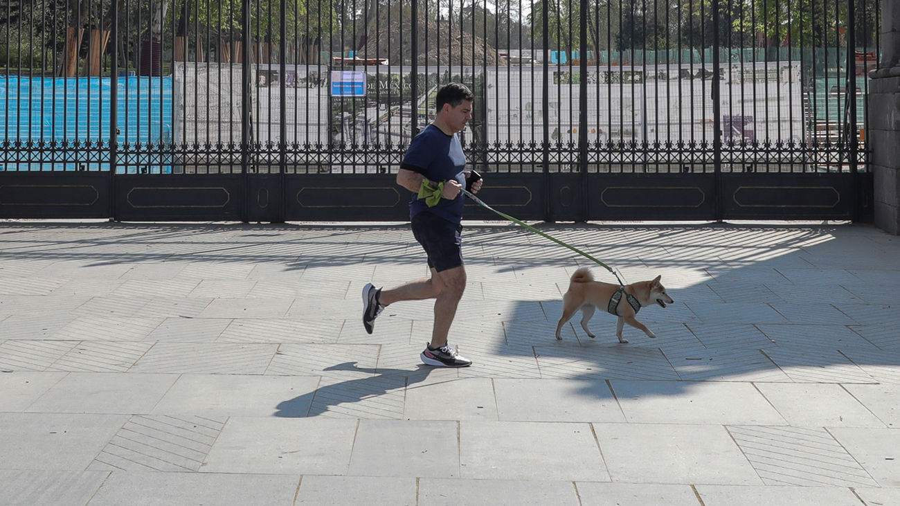 Un corredor con su perro, ante el parque de El Retiro