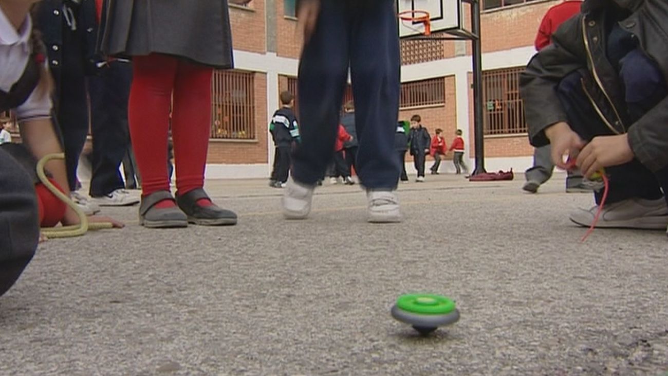 Unos niños juegan a la peonza en el patio de un un colegio en el tiempo de recreo (Archivo)