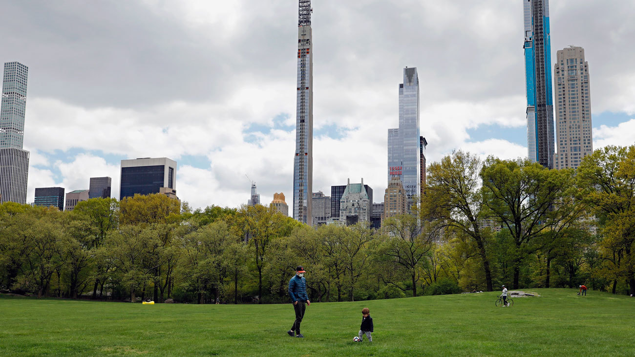 un padre juega al fútbol con su hijo en el Central Park