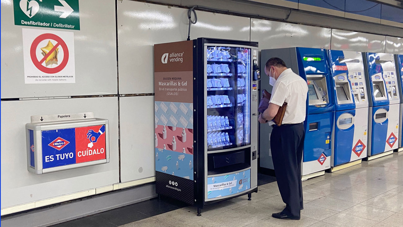 Un usuario de Metro compra una mascarilla en una máquina expendedora
