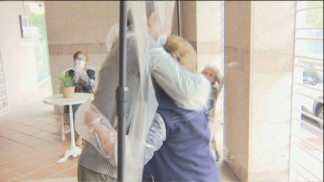 Reencuentros familiares con abrazos plastificados en las residencias de mayores de Madrid