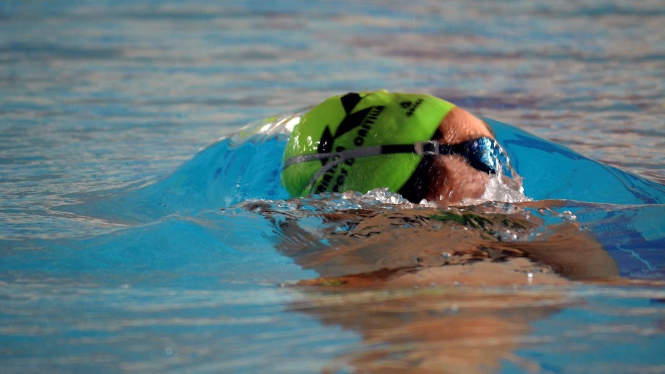 Una mujer nada en una piscina