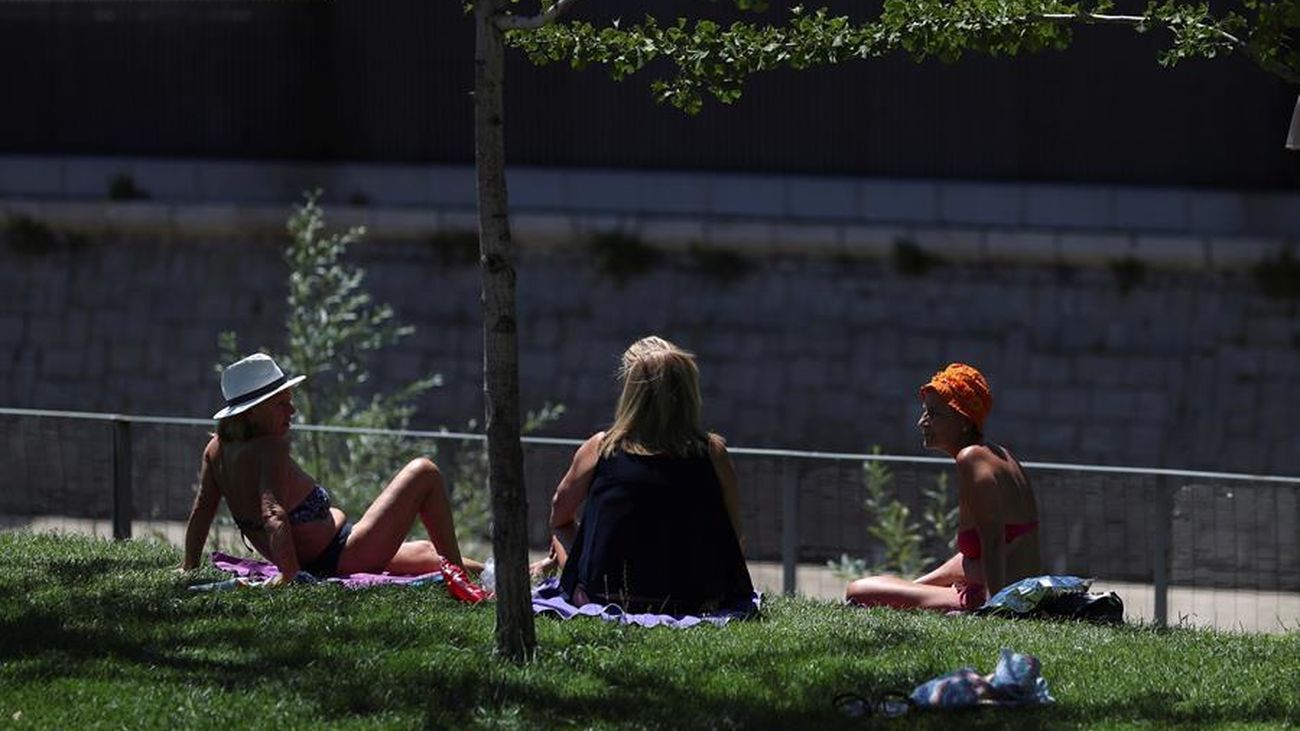 Tres mujeres toman el sol en los jardines de Madrid Rio