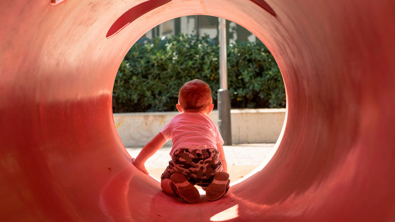 Un niño pequeño juega en un parque infantil