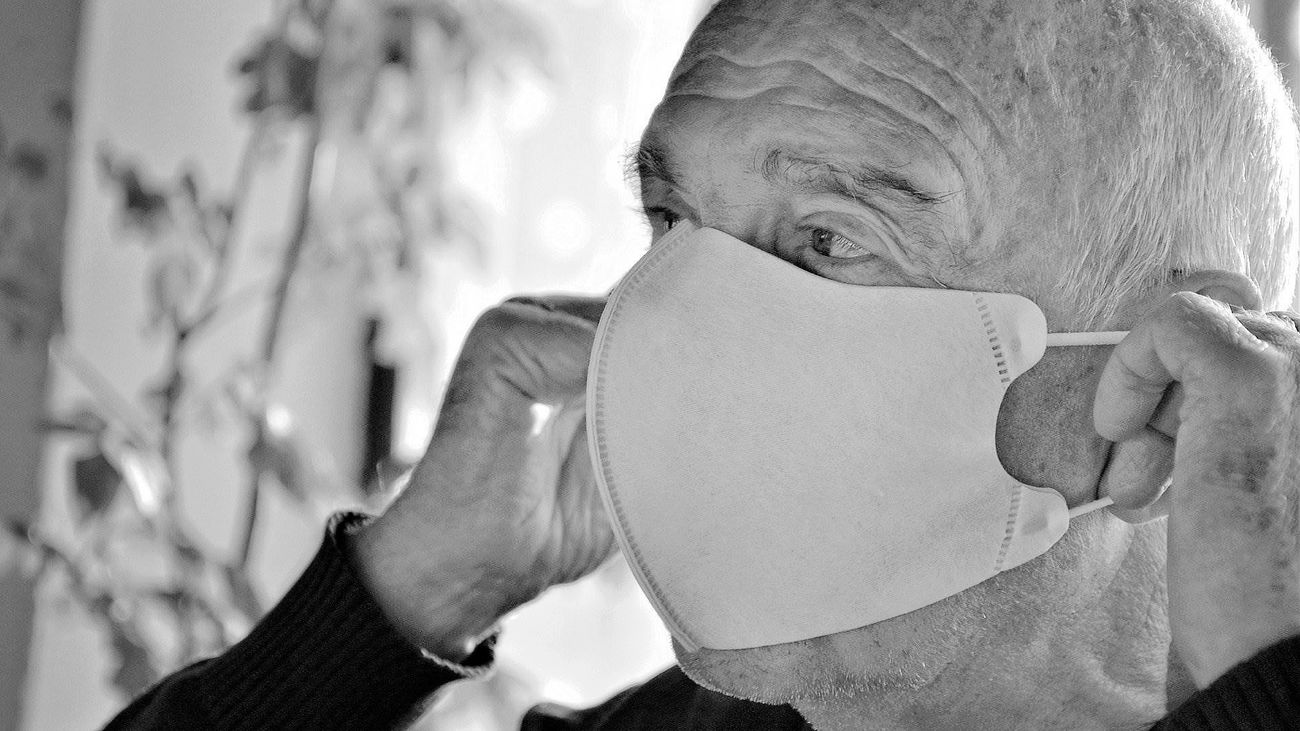 Un hombre mayor se coloca la mascarilla
