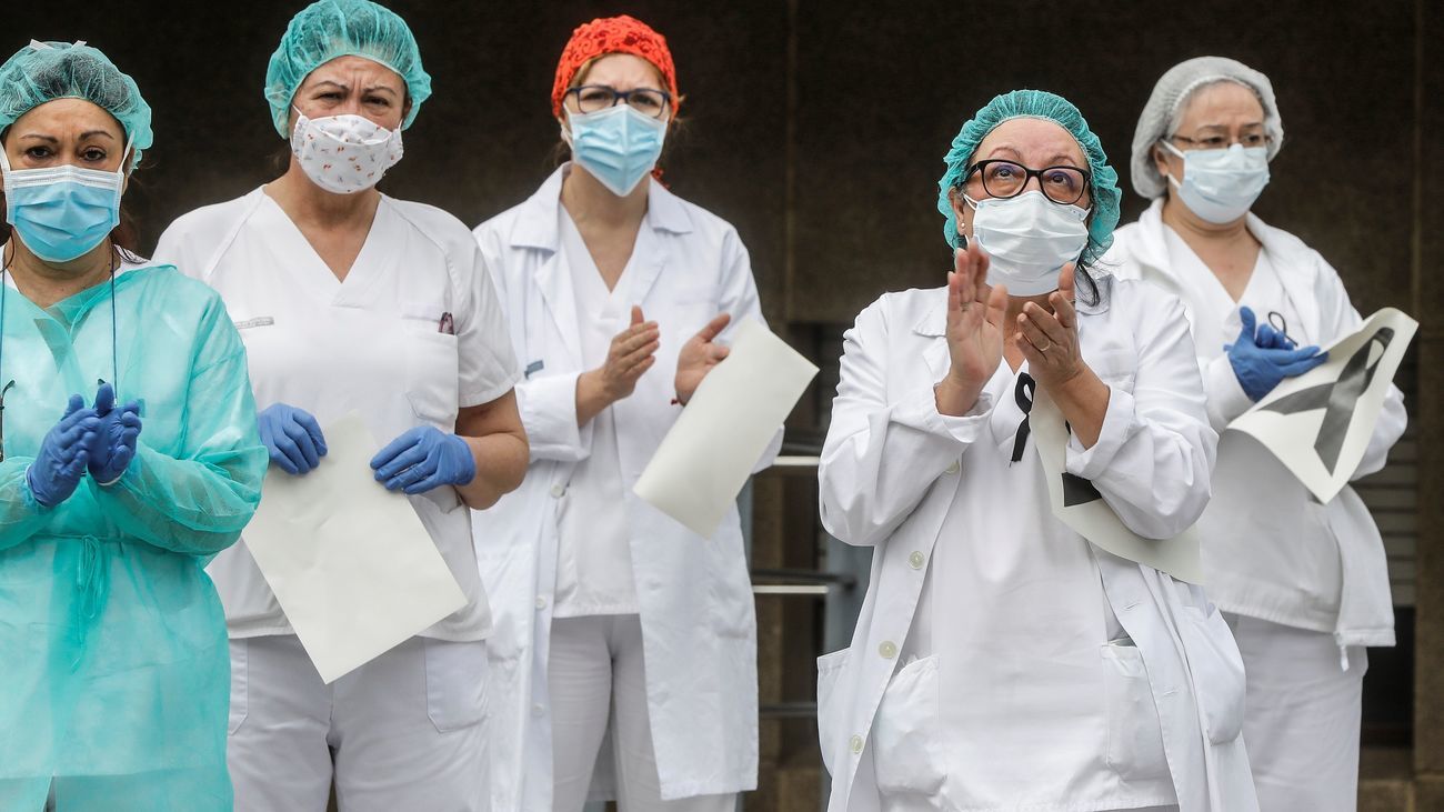 Un grupo de sanitarios aplaude a las puertas de un centro hospitalario