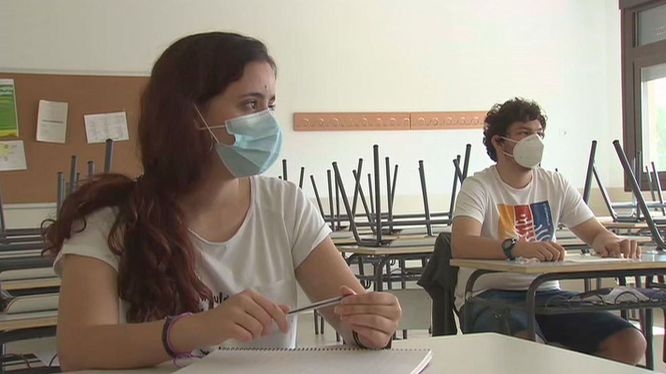 Alumnos con mascarilla atienden en clase